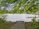 Gravel path leading to a platform with direct access to the serene lake, surrounded by lush greenery at 291 Preston Rd, Mooresville, NC 28117