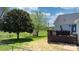 Large fenced backyard featuring trees, a shed, a wooden deck, and a lush green lawn at 4808 Thoreau Dr, Conover, NC 28613