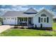 Charming single-story home features a well-manicured lawn and a welcoming front porch with decorative plants at 4808 Thoreau Dr, Conover, NC 28613