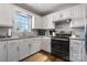 Bright kitchen features white cabinets, stainless appliances, light backsplash, and hardwood flooring at 4808 Thoreau Dr, Conover, NC 28613