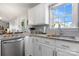 Bright kitchen featuring white cabinets, granite countertops, a stainless dishwasher, and light backsplash at 4808 Thoreau Dr, Conover, NC 28613