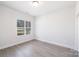 Bright, empty bedroom with minimalist decor showcasing new hardwood style flooring at 4907 Victoria Ave, Charlotte, NC 28269