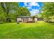 This well-maintained backyard features a spacious lawn, a deck, and mature trees for shade at 509 Carole Ln, Charlotte, NC 28214