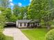 A charming single-story home featuring lush greenery, a covered porch, and a convenient two car garage at 509 Carole Ln, Charlotte, NC 28214