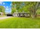 Charming single-story home featuring a well-manicured lawn, a covered porch, and a detached two car garage at 509 Carole Ln, Charlotte, NC 28214