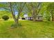 Quaint single-story home featuring mature trees, a spacious front yard, and a detached two car garage at 509 Carole Ln, Charlotte, NC 28214