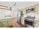 Galley kitchen with light green cabinets and stainless steel appliances at 509 Carole Ln, Charlotte, NC 28214