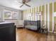 Bedroom with hardwood floors, striped walls, crib, and decor at 714 S 8Th St, Bessemer City, NC 28016
