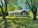 Charming one-story home featuring a well-maintained lawn and beautiful mature shade trees at 835 Leach Rd, Salisbury, NC 28146