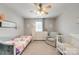 Bedroom with neutral carpet, ceiling fan, a bed, a crib, a dresser, and an armchair at 861 Watling St, Fort Mill, SC 29715
