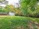 Large, grassy backyard featuring a storage shed, mature trees, and a fenced perimeter at 8718 Rittenhouse Cir, Charlotte, NC 28270