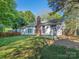 The backyard features a well-kept lawn, a brick chimney and mature trees at 8718 Rittenhouse Cir, Charlotte, NC 28270