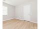 Bedroom featuring wood-look flooring, a window with blinds and a white door at 8718 Rittenhouse Cir, Charlotte, NC 28270