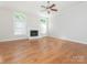Bright living room featuring hardwood floors, fireplace, neutral paint and large windows for ample natural light at 8718 Rittenhouse Cir, Charlotte, NC 28270