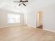 Main bedroom featuring wood-look flooring, a ceiling fan, and a view of an ensuite bath at 8718 Rittenhouse Cir, Charlotte, NC 28270