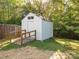 Exterior view of a backyard shed with ramp and fenced perimeter, offering functional storage space at 8718 Rittenhouse Cir, Charlotte, NC 28270