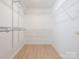 Bright walk-in closet featuring white wire shelving and light hardwood flooring at 8718 Rittenhouse Cir, Charlotte, NC 28270