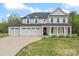 Beautiful two-story home featuring a three-car garage, a green lawn, and a charming entrance at 8756 Sherrills Ford Rd, Sherrills Ford, NC 28673