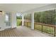Covered porch featuring wood flooring, wood railings, and a door leading to the backyard space at 8756 Sherrills Ford Rd, Sherrills Ford, NC 28673