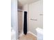 This bathroom features a stand-up shower with black curtain, towel racks and neutral walls at 9668 Walkers Glen Nw Dr, Concord, NC 28027
