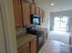 Kitchen featuring wood cabinets, tile floors and black appliances with natural lighting at 9668 Walkers Glen Nw Dr, Concord, NC 28027