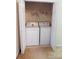 This laundry closet features a washer and dryer, and double doors for convenience at 9668 Walkers Glen Nw Dr, Concord, NC 28027