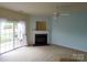 View of a bright living room featuring a fireplace and sliding doors to the backyard at 9668 Walkers Glen Nw Dr, Concord, NC 28027