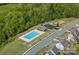 Aerial view of community pool, playground, and surrounding homes in a well-maintained neighborhood at 9867 Travertine Trl, Davidson, NC 28036