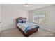Bedroom featuring a full-sized bed, a window, carpet, and a colorful comforter with a panda stuffed animal at 9867 Travertine Trl, Davidson, NC 28036