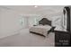Spacious bedroom with tray ceiling features carpet, windows and furniture at 9867 Travertine Trl, Davidson, NC 28036