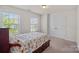 Bright bedroom features two windows, light neutral walls, and closet with double doors at 9867 Travertine Trl, Davidson, NC 28036