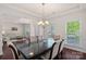 Elegant dining room with dark wood floors, a modern chandelier, and large windows at 9867 Travertine Trl, Davidson, NC 28036
