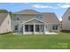 Rear exterior featuring a screened in porch and concrete patio at 9867 Travertine Trl, Davidson, NC 28036