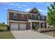 Charming two-story brick home features a spacious two-car garage and well-manicured landscaping at 9867 Travertine Trl, Davidson, NC 28036