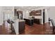 Spacious kitchen features a central island, granite countertops, stainless steel appliances, and dark wood flooring at 9867 Travertine Trl, Davidson, NC 28036