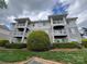 Attractive condo building showcasing multiple balconies, well-maintained lawns, and professional landscaping under a cloudy sky at 10005 Graduate Ln, Charlotte, NC 28262