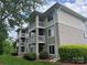 Inviting condominium exterior featuring multi-level balconies and landscaped grounds on a partly sunny day at 10005 Graduate Ln, Charlotte, NC 28262