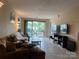 Comfortable living room featuring tile floors, couches, and sliding glass doors to a balcony at 10005 Graduate Ln, Charlotte, NC 28262