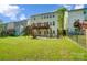 Expansive backyard showcasing a two-level deck, concrete patio, and lush green lawn at 10056 Paisley Dr, Charlotte, NC 28269