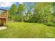 Large, well-maintained backyard features lush green grass and a backdrop of mature trees and privacy fence at 10056 Paisley Dr, Charlotte, NC 28269