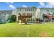 Large backyard with a two-level wooden deck, a concrete patio, and mature landscaping at 10056 Paisley Dr, Charlotte, NC 28269