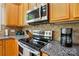 Close-up of modern kitchen appliances on granite countertops, including stainless steel microwave and oven at 10056 Paisley Dr, Charlotte, NC 28269
