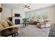 Bright living room featuring a fireplace, ceiling fan, and large windows with natural light at 10056 Paisley Dr, Charlotte, NC 28269