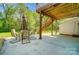 View of a covered concrete patio with outdoor dining and a wooden staircase to the deck at 10056 Paisley Dr, Charlotte, NC 28269
