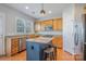 Well-lit kitchen with an island, stainless steel appliances, granite countertops, and wooden cabinets at 10354 Scotland Ave, Fort Mill, SC 29707
