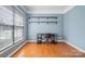 Office space with wooden floors, large window, floating shelves and an office chair at 10354 Scotland Ave, Fort Mill, SC 29707