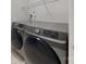 Modern laundry room featuring front load washer and dryer with wire shelving for storage of laundry supplies at 10526 Hill Point Ct, Charlotte, NC 28262