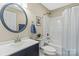 Bathroom with vanity, toilet, and tub/shower combo with blue accents at 109 W Poplar St, Stanley, NC 28164