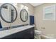 Modern bathroom features double sinks, decorative mirrors, elegant lighting, and a window for natural light at 109 W Poplar St, Stanley, NC 28164