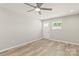 Bright living room features wood-look flooring, a ceiling fan, and a white door to the exterior at 109 W Poplar St, Stanley, NC 28164